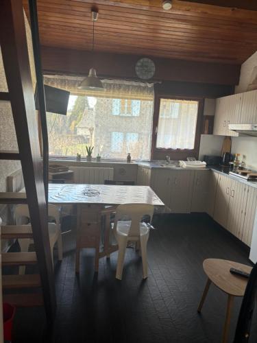 une cuisine avec une table et des chaises dans l'établissement Duplex rénové dans résidence privé proche de toutes commodités place de parking inclu, à La Bourboule