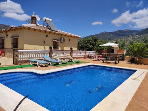 a swimming pool in front of a house at Los Olivos in Málaga