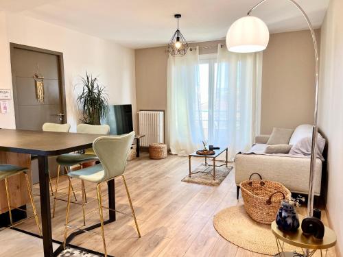 un salon avec une table et un canapé dans l'établissement Appart’ Chaleureux avec balcon/800m Gare et centre, à Valence