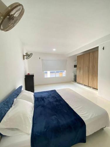 1 dormitorio con 1 cama grande con manta azul en Palma House - Cabaña con piscina, en Tubará