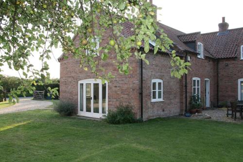 a brick house with a green lawn in front of it at Self contained annexe in the Vale of Belvoir. in Nottingham