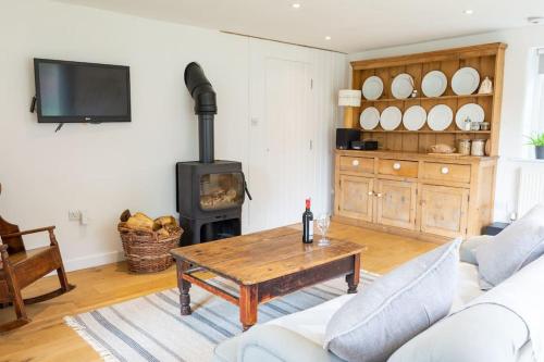 a living room with a table and a wood stove at Self contained annexe in the Vale of Belvoir. in Nottingham