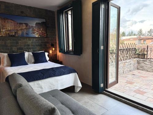 ein Schlafzimmer mit einem Bett und einem großen Fenster in der Unterkunft Loft Venezia II Val'Quirico 4Pax, terraza privada in Santeagueda