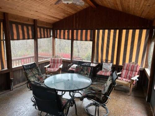 a screened in porch with a table and chairs at Luxury Cabin #21 With Hot Tub and Jacuzzi on Patoka Lake in Southern Indiana in Paoli