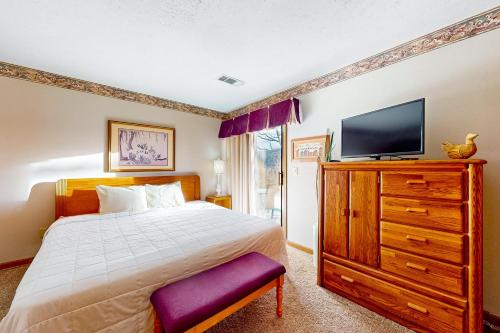 a bedroom with a bed and a tv on a dresser at Minutes from Everything in Branson