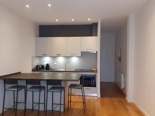 une cuisine avec un îlot et des tabourets de bar dans l'établissement La halle aux grains, à Toulouse