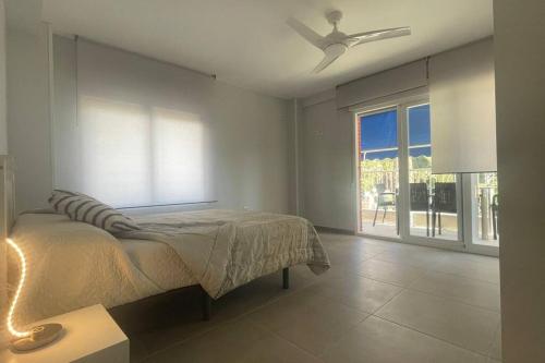 sypialnia z łóżkiem i wentylatorem sufitowym w obiekcie Apartamento moderno y coqueto en playa San Juan w Alicante