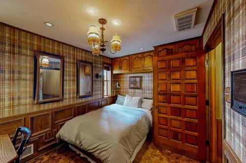 een slaapkamer met een bed in een kamer met houten wanden bij The Castle on Cedar Creek Lake in Tool