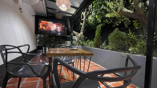 a patio with a table and chairs and a tv at Hotel BJ Curumani in Curumaní