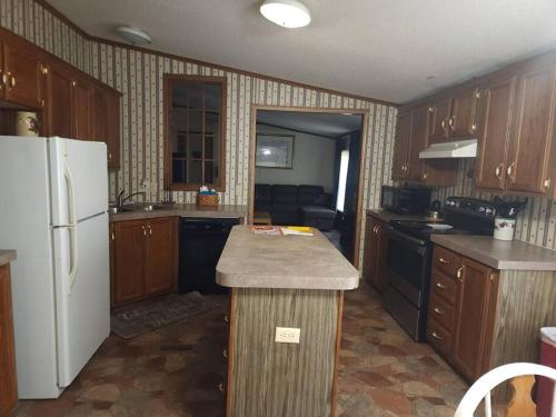 a kitchen with wooden cabinets and a white refrigerator at Family Style Home #22 on Patoka Lake in Southern Indiana in Eckerty