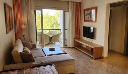 uma sala de estar com um sofá e uma televisão em First Class at Naama Bay Hotel Appartments em Sharm el Sheikh