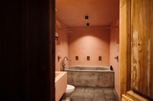a bathroom with a tub and a toilet and a sink at Maison Mexique Hotel Boutique San Miguel de Allende in San Miguel de Allende