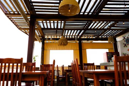a dining room with wooden tables and chairs at Santa Martha Bungalows in Los Ayala