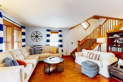 a living room with white couches and a wooden floor at Vitamin Beach 12 in Avon