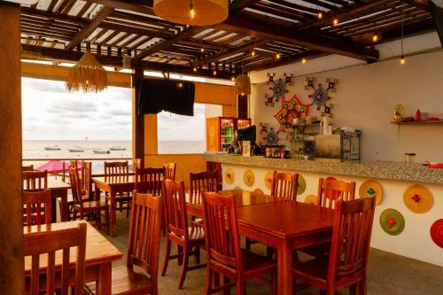 a restaurant with wooden tables and chairs and the ocean at Santa Martha Bungalows in Los Ayala