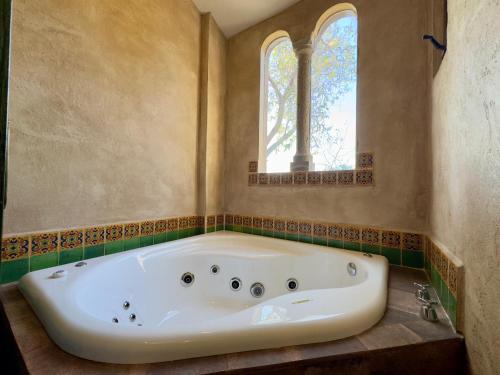 a bath tub in a bathroom with a window at Loft El Tapatío en Val'Quirico in Santeagueda