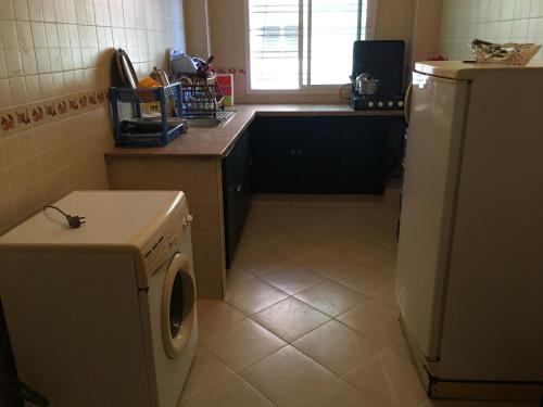 uma cozinha com uma máquina de lavar roupa e uma janela em Bel appartement au calme, proche du centre ville em Kenitra