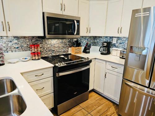 a kitchen with white cabinets and a black stove top oven at Pensacola, Oceanfront Paradise With Private Beach in Pensacola Beach