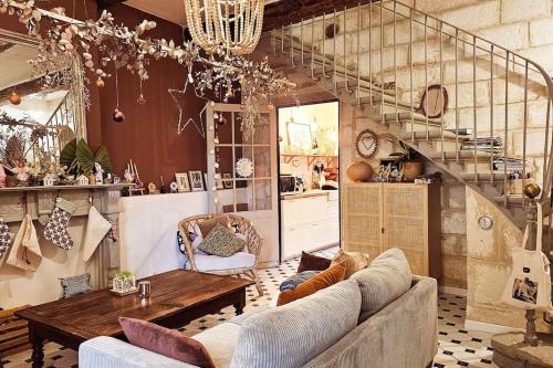 uma sala de estar com um sofá e uma escada em Chic & Bohème Proche Avignon em Vedène