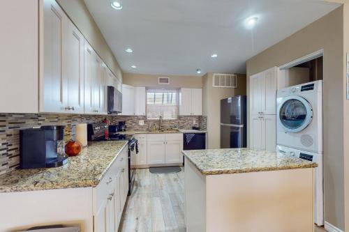 a kitchen with white cabinets and a washer and dryer at Mariner Village 108 in Seabrook