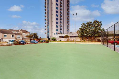 a tennis court in front of a tall building at Mariner Village 108 in Seabrook