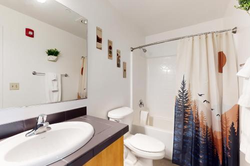 a bathroom with a sink and a toilet and a shower curtain at Putnam Pointe Perch #510 in Bend