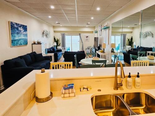 a kitchen and living room with a sink and a couch at Pensacola, Oceanfront Paradise With Private Beach in Pensacola Beach