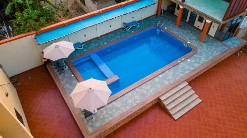 an overhead view of a swimming pool with umbrellas at Royal N Hotel in Accra