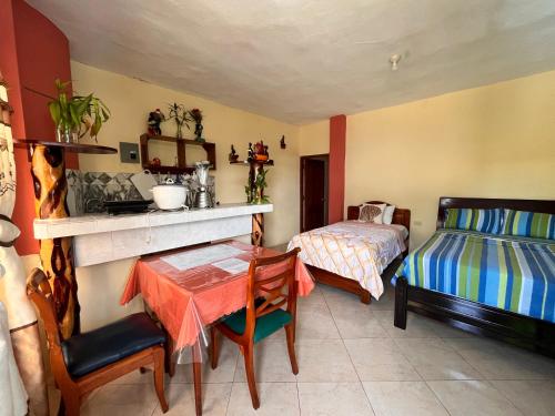 una camera con tavolo e letto e una camera da letto di Casa de Huéspedes Paola a Puerto Baquerizo Moreno