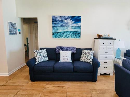 a living room with a blue couch and a dresser at Pensacola, Oceanfront Paradise With Private Beach in Pensacola Beach