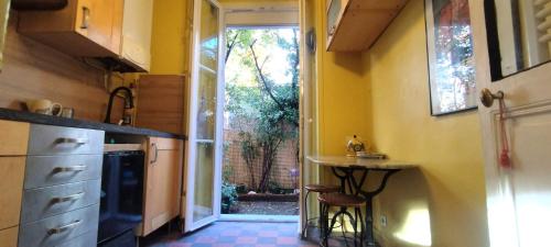 une cuisine avec un évier et une table à l'intérieur dans l'établissement Appartement de charme avec jardin, à Puteaux