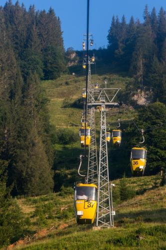 a group of yellow gondolas on a ski lift at Alpin & Wellness Resort Ludwig Royal in Oberstaufen