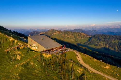 a large building on a hill with a crowd of people at Alpin & Wellness Resort Ludwig Royal in Oberstaufen