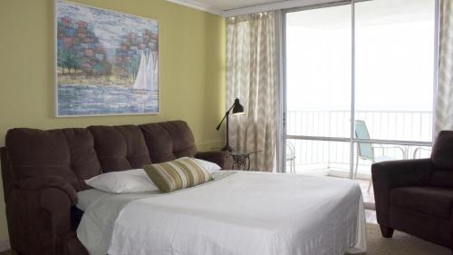 Un dormitorio con una cama y un sofá y una ventana. en El Capitan, en San Juan