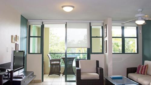 a living room with a couch and chairs and windows at Sandy Cove in Rio Grande