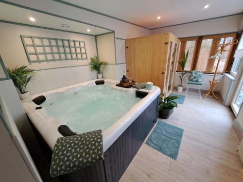 eine Whirlpool-Badewanne in der Mitte eines Zimmers in der Unterkunft Le Logis Fleurs et jardins de Pitry 