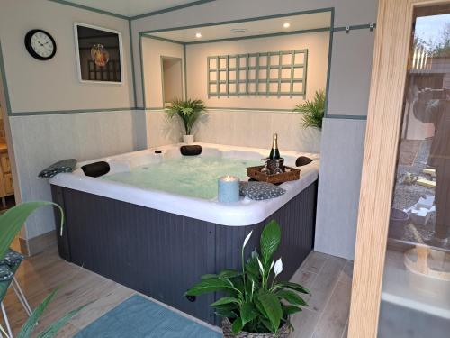 a jacuzzi tub with a bottle of wine in it at Le Logis Fleurs et jardins de Pitry in Thierville