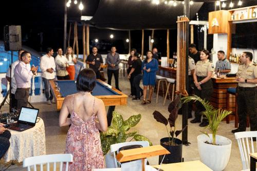 un grupo de personas de pie en una habitación con mesa de billar en Fernandina Hotel & Spa en Puerto Ayora