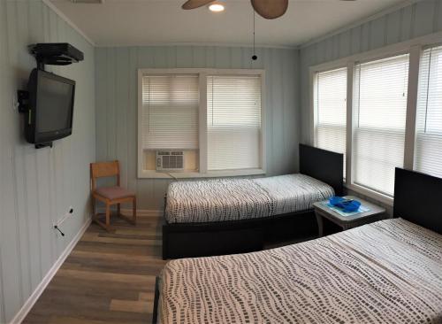 a room with two beds and a flat screen tv at 6B Best Location, 4 bedrm, 2 bathrm Beach Block in Seaside Heights