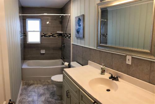 a bathroom with a sink and a toilet and a tub at 6B Best Location, 4 bedrm, 2 bathrm Beach Block in Seaside Heights