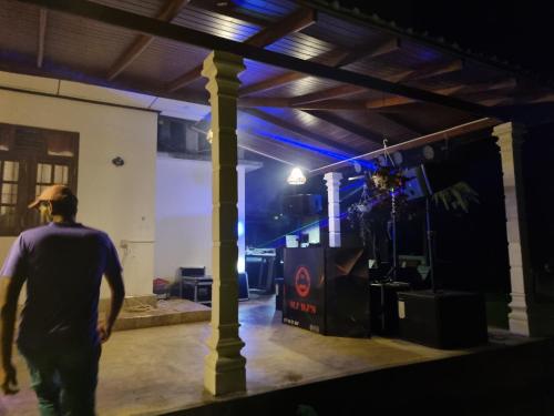 a man walking through a garage at night at JAYANDRA HOLIDAY BUNGALOW in Waga