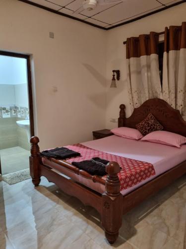 a bedroom with a bed with pink sheets and a window at JAYANDRA HOLIDAY BUNGALOW in Waga