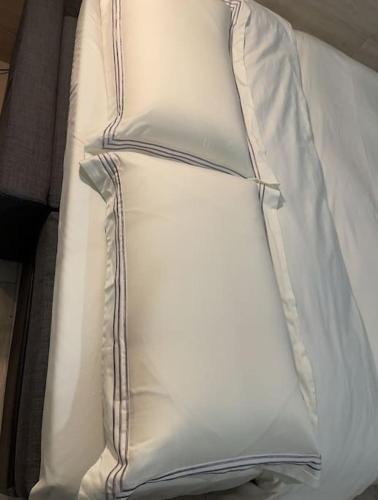 una pila di cuscini bianchi su un letto di Monolocale a 200 mt stazione a Napoli