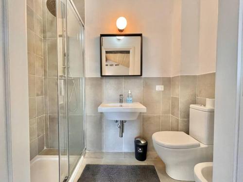 a bathroom with a toilet and a sink and a shower at Attico Tre Cuori Castione in Castione della Presolana