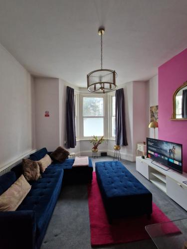 a living room with a blue couch and a tv at Lovely One Bed Apartment in St Leonards in St. Leonards