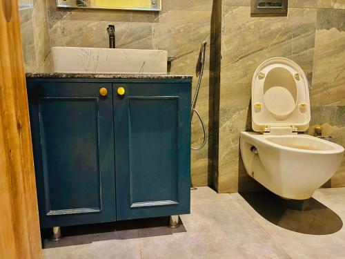 a bathroom with a blue cabinet and a toilet at Hotel GOOD LUCK HOUSE Near Delhi Airport in New Delhi
