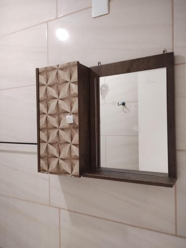 a mirror sitting on a shelf in a bathroom at Casa das Embaúbas 5 in São José