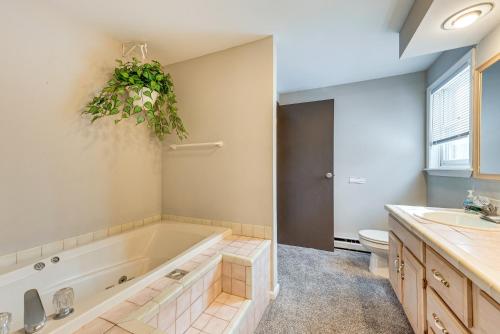 a bathroom with a tub and a sink and a toilet at Arrowhead Lake Retreat with Private Indoor Pool! in Pocono Lake