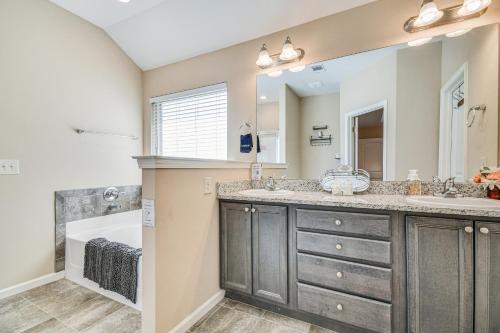 a bathroom with two sinks and a large mirror at Prattville Home with Fire Pit - 2 Mi to Downtown! in Prattville