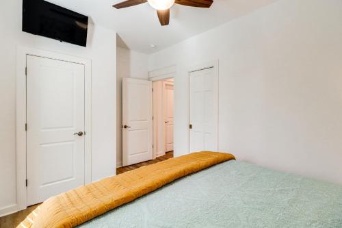 a bedroom with a bed and a ceiling fan at The Hamilton Heber Springs Home with Hot Tub! in Heber Springs